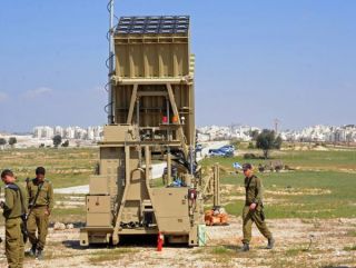 Israeli soldiers stand near the new Israeli anti rocket system, the